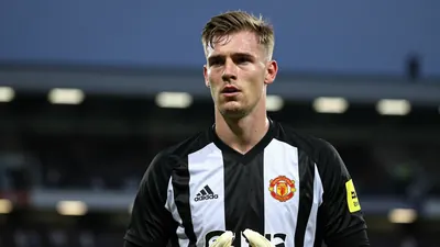 Mid-20s male goalkeeper, athletic build, waist-up, wearing Newcastle United black-and-white home kit with the Magpies...