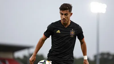 A 24-year-old Spanish midfielder with a strong build, wearing a solid black jersey, photographed with an 85mm f/1.4 lens...
