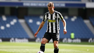 A head-and-shoulders photo of a young, athletic, and smiling Swedish player wearing Newcastle United's black and white...