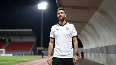 A photorealistic image of a 38-year-old German coach in a white shirt with a black collar and sleeves, and black shorts...