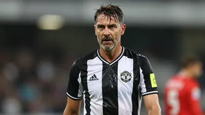 Middle-aged German coach, athletic build, waist-up, wearing Newcastle United black-white home shirt with crisp crest on...