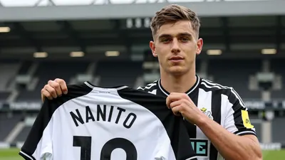 A 17-year-old male football player, lean build, wearing a Newcastle United shirt in solid black and white stripes...