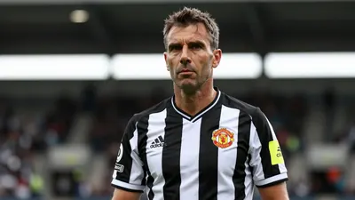 Middle-aged male manager, athletic build, mid-40s, wearing Newcastle United black-and-white home shirt with the Magpies...