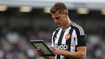 Mid-30s male scout, athletic build, waist-up, wearing Newcastle United black-white home shirt with the Magpies crest on...