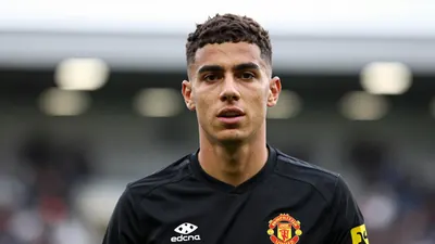 A young, athletic midfielder in his early twenties, wearing a solid black Newcastle United training kit...