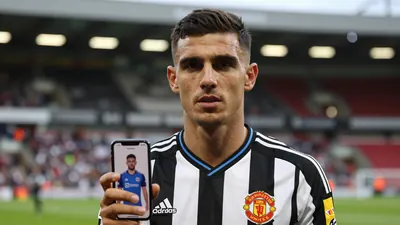 Mid-shot of a 28-year-old athletic male scout, short dark hair, intense eyes, wearing a Newcastle United home shirt...